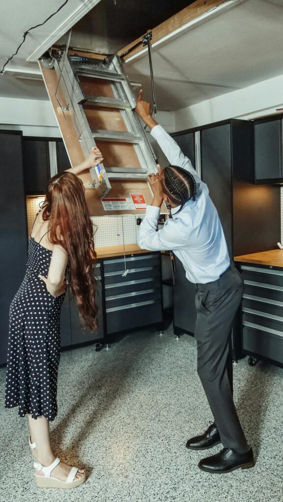 A man and woman inspecting an attic in a modern apartment setting.